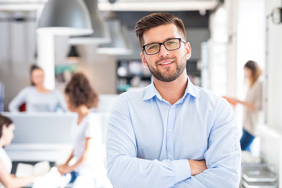 Business Insurance - Business Portrait of Young Confident Man Stanidng with Arms Crossed in the Office